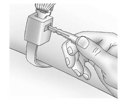 2. Disconnect the rear safety belt mini-latch using a key in the slot on the